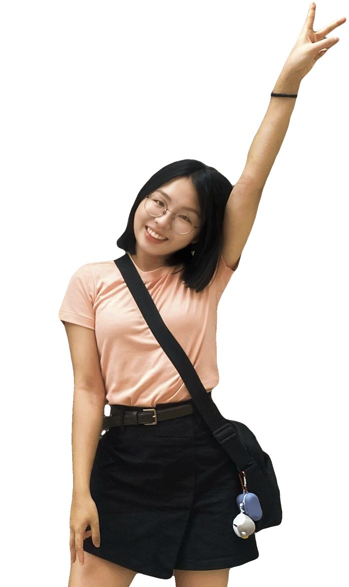 ME! A smiling young woman with glasses and short black hair, wearing a peach t-shirt and black shorts, stands with one arm raised making a peace sign. She has a black crossbody bag with a keychain attached.